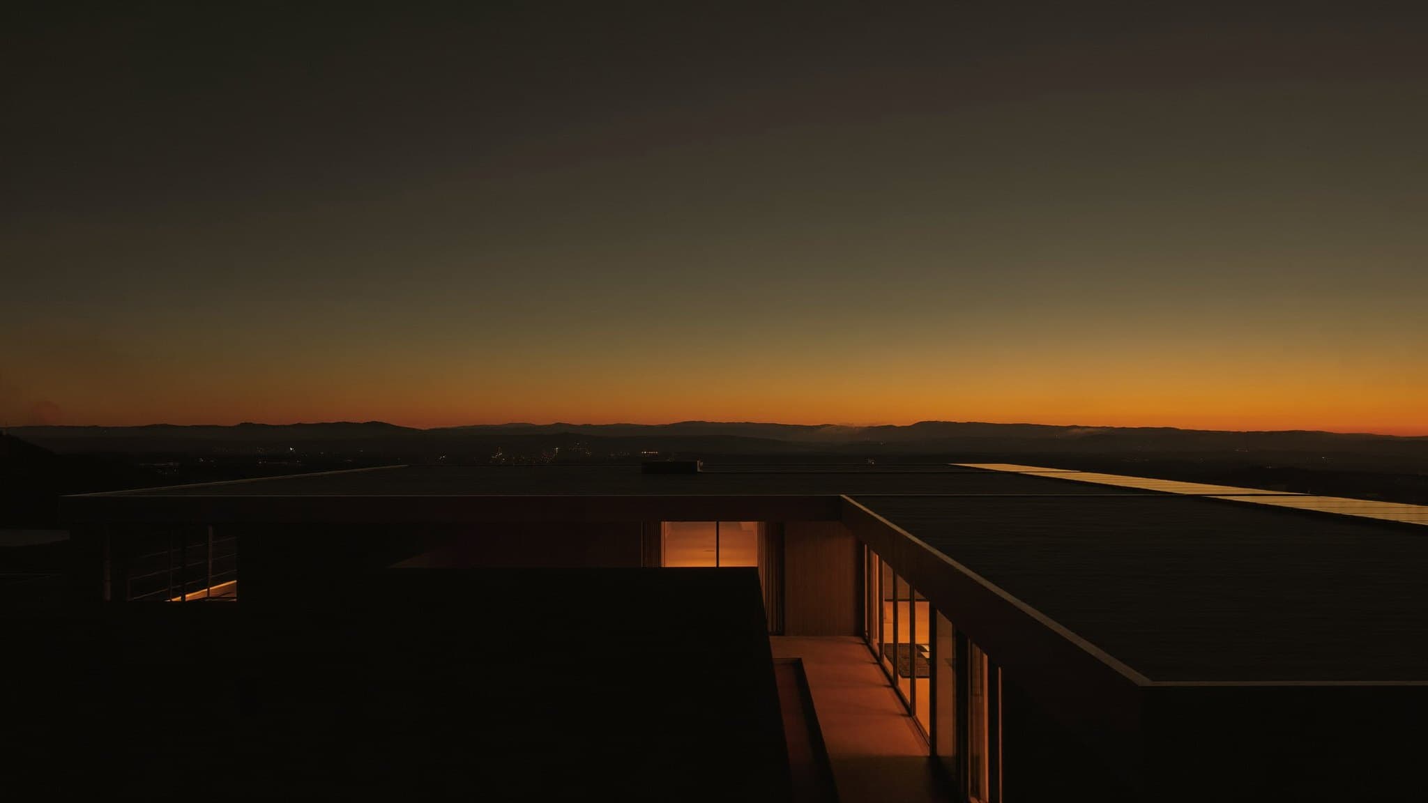 Casa moderna con paneles solares iluminada al anochecer